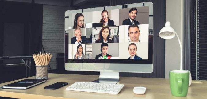 Does ZOOM Present Cybersecurity Vulnerabilities? An image of a ZOOM video conference on an employee's computer, showing 9 coworkers in a gallery view meeting